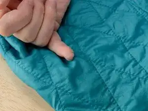 Repairing a Loop of Loose Stitching in an Insulated Jacket