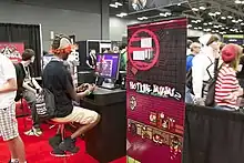 A man playing a demo version of Hotline Miami 2: Wrong Number at a booth during the RTX 2014 in Austin, Texas.