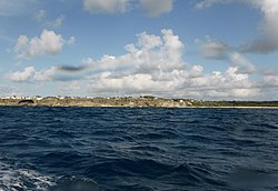 To the south west of Foul Bay, Oliver's cave, Ocean City is topped by a precarious house, Centre of picture. Little Bay is right of Centre. Part of Foul Bay is extreme right. Viewed from The Fathom.